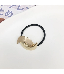 Detail of minimalist golden moon-shaped metal accent on a high-elasticity black hair tie