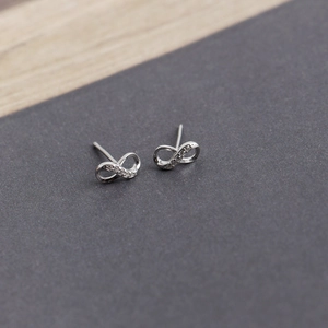 Macro detail of silver infinity S925 earrings with small cubic zirconia stones