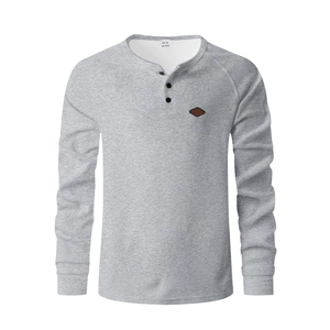 Detail of grey waffle knit Henley shirt with three-button placket and leather chest patch