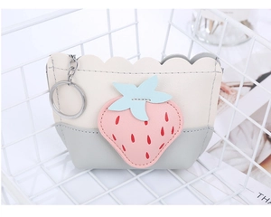 Detail of strawberry-shaped coin purse with pink patch and silver keychain ring