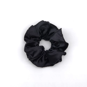 Large black satin scrunchie with elegant folds for ballet core style buns on white background