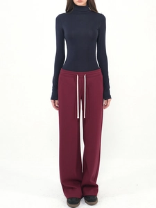Detail of high neck navy top and burgundy drawstring wide leg trousers for women