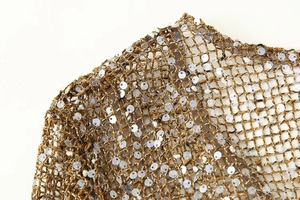 Détail macro du tissu en maille marron doré avec des paillettes argentées scintillantes