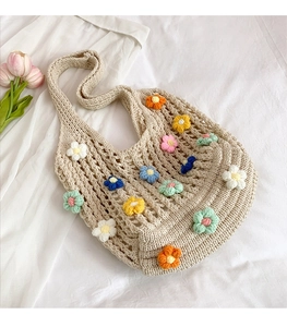 Detailed view of handmade hollow knit tote bag with 3D crochet floral embellishments