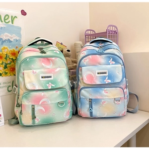 Detail of gradient blue and pink backpacks with moon and butterfly prints for students