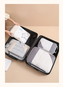 Travel luggage organizer set with grey and beige storage bags neatly arranged in a suitcase