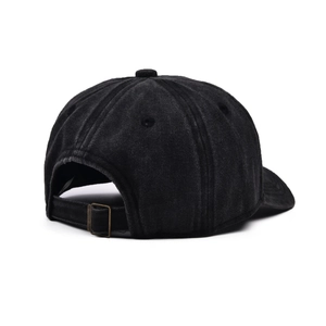Detail view of the back of a washed distressed black baseball cap with adjustable strap
