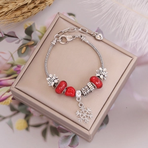 Detail of Christmas beaded bracelet with red glass beads and silver snowflake pendant