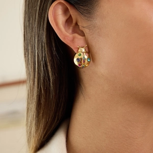 Lively gold ladybug stud earring with vibrant multicolor crystals on a female model