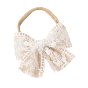 Baby girl nylon headband with large white lace bow and floral embroidery detail