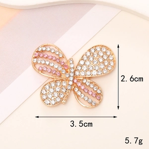 Macro shot of gold butterfly pin with pink crystals measuring 2.6cm by 3.5cm