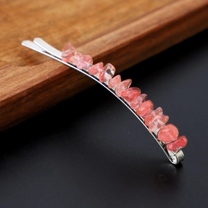 Macro shot of natural pink crystal stones on a polished silver metal hairpin base