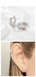 Détail de boucles d'oreilles étoile argentées avec zircons sur un modèle d'oreille