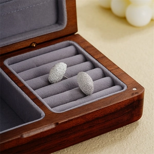 Frosted silver moon-shaped geometric stud earrings displayed on a luxury wooden jewelry box