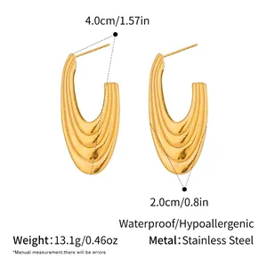 Vue détaillée des boucles d'oreilles dorées en forme de U avec dimensions et texture