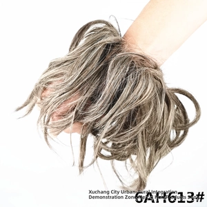 Detail showing the elastic stretch and messy texture of dark brown and blonde hair bun extension