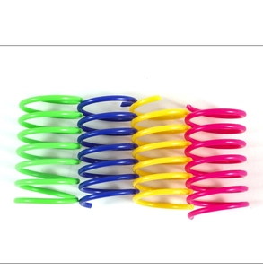 Overhead view of colorful plastic spiral spring cat toys in pink, blue, yellow, and green