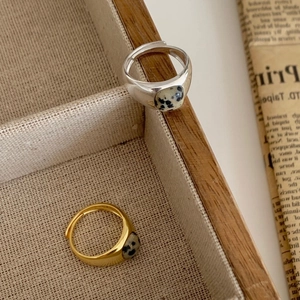 Adjustable silver and gold rings with marble stones on a wooden vintage jewelry tray