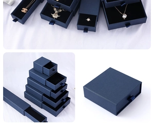 Detail of dark blue drawer-style jewelry boxes with ribbon pulls in various sizes