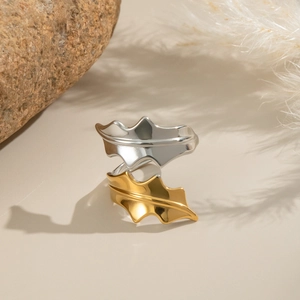 Detailed view of bicolor leaf ring on elegant beige setting with organic background