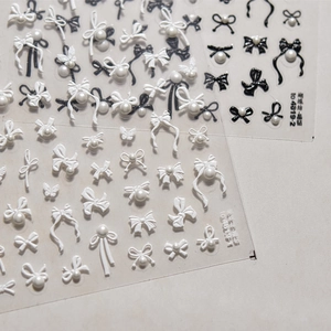 Detail view of 3D bow and pearl nail stickers in black and white styles, models TO 4819