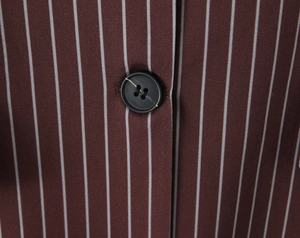Close-up of brown striped fabric with a black four-hole button on this casual blazer