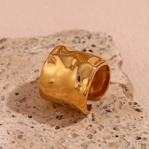 Dettaglio di un anello largo placcato oro 18K con una texture ondulata martellata unica