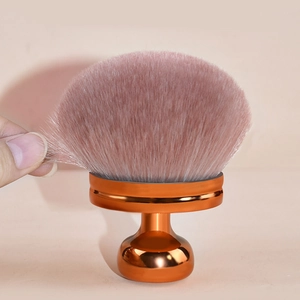 Large mushroom powder brush with soft pink bristles and gold metal base for makeup