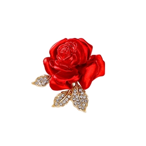 Elegant red rose brooch with gold leaves and sparkling crystals on white background