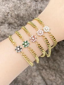 Close-up of five colorful flower charm bracelets with gold plating on a hand