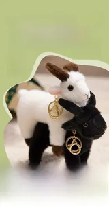 Close-up of black and white plush goat keychains with gold metal clips on soft background