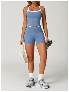 Femme portant un ensemble de yoga bleu brume avec bordure contrastée blanche et short taille haute