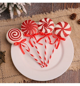 Detail of red and white glitter spiral lollipop ornaments on a festive pine display