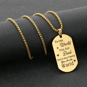 Detail of engraved gold dog tag pendant showing a heartfelt message for fathers