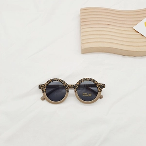 Close-up of leopard and beige round frame kids sunglasses with UV400 protection logo