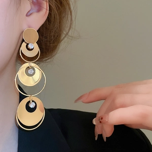 Close-up of gold layered circular fringe earrings with zircon on female model