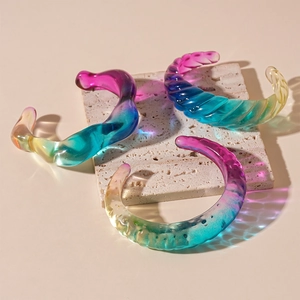 Detailed close-up of acrylic resin bangles with colorful gradients on stone