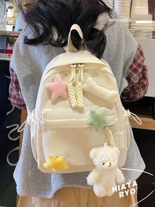 Minimalist beige student backpack featuring colorful star charms and a cute plush bear