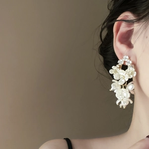 Macro shot of shell flower earrings with zircon long tassel drops on a female model