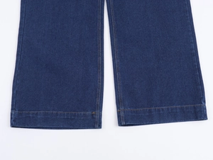 Détails du bas de pantalon en jean bleu foncé avec des coutures contrastées jaunes