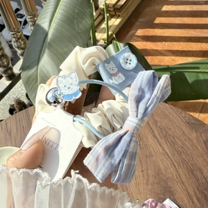 Close-up of hair scrunchie set with blue plaid bow, button detail and dog charm