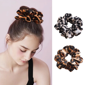 Detail of vintage leopard print scrunchies in brown and grey fabric on model and white background