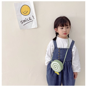 Close-up of a green lollipop-shaped kids' crossbody bag with adjustable shoulder strap