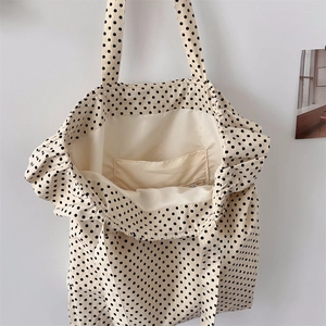 Detailed interior of polka dot canvas tote bag showing the inner pocket and cream fabric