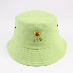 Gros plan sur la broderie de tournesol et les œillets du chapeau bob vert clair
