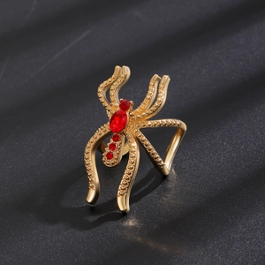 Détail de la bague araignée punk avec placage à l'or et incrustation de cristaux rouges