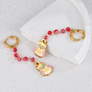 Colorful beaded owl drop earrings with gold hoops and red facets on white stone