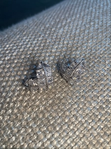 Macro shot of silver heart studs featuring pavé-set zircons and a quilted metal texture