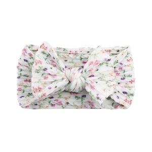 Detailed view of white nylon baby headband with pink floral print and soft double bow knot