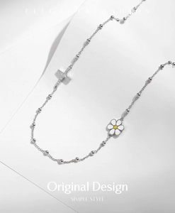 Close-up of s925 silver cross pendant with full crystals and white daisy charm detail